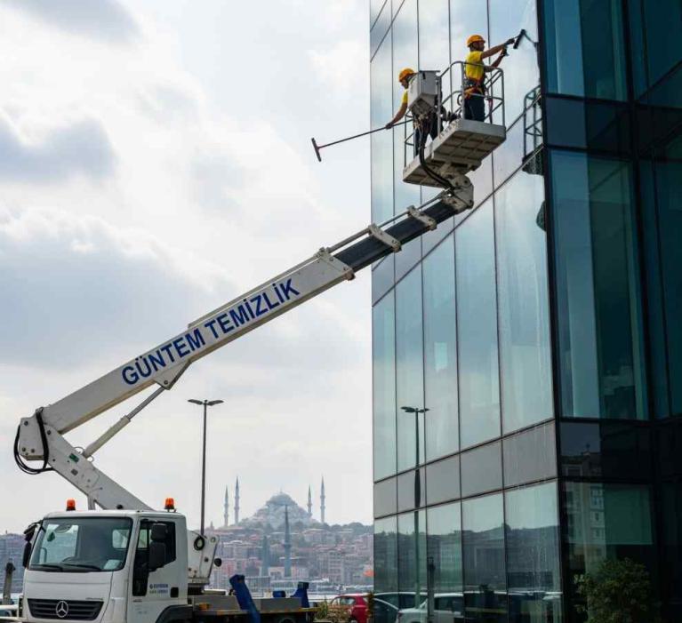 Sepetli vinç erişimiyle yapılan profesyonel dış cephe cam temizliği uygulaması.